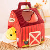 Red barn-shaped toy with a duckling on a woven surface